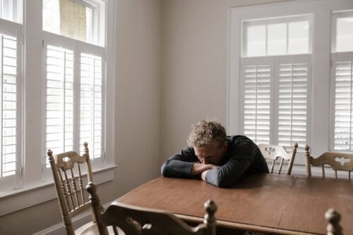 man exhausted at table