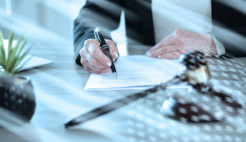 A person in business attire signs a document at a desk with a gavel, pen, and small potted plant nearby, suggesting a legal setting. The scene hints at handling matters like divorce without lawyer guidance. Light streaks cross the image.